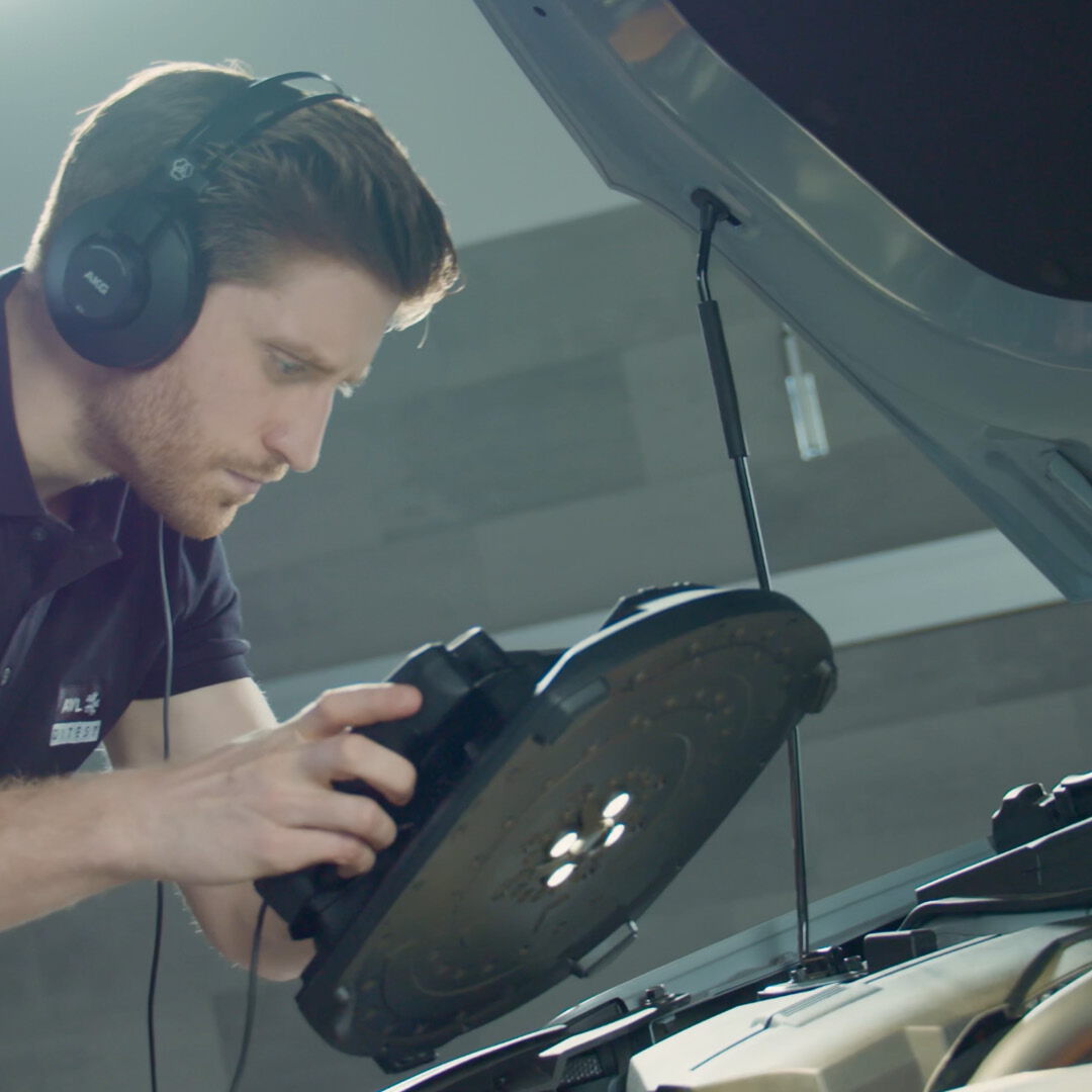 Video thumbnail on the topic of technical consulting: A young consultant with headphones focuses on analyzing a piece of electronic hardware.