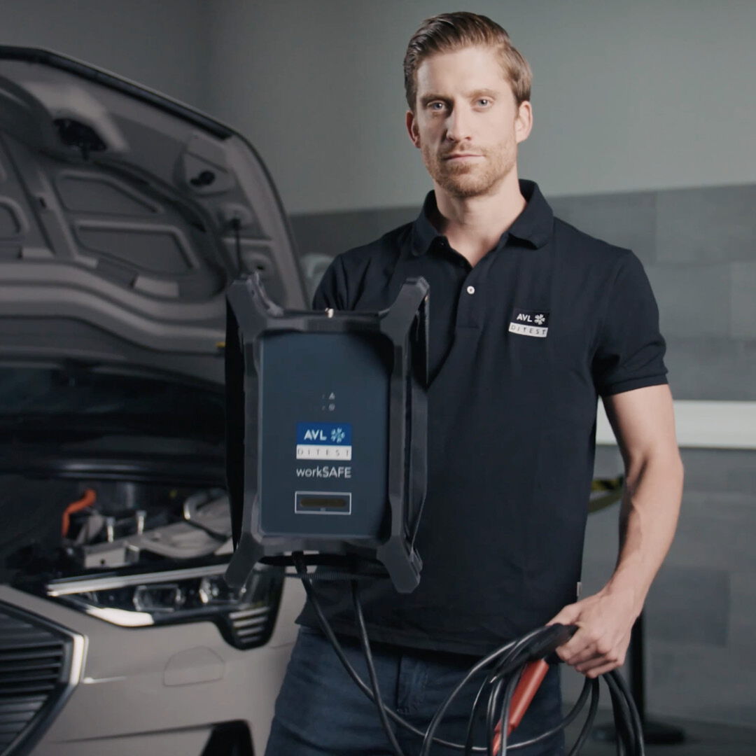 Video thumbnail on the topic of hardware: A friendly employee in AVL DiTEST workwear stands in a workshop.